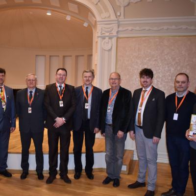 Spaudos konferencijai Palangos kurhauze pasibaigus su XVIII-ojo Lietuvos pučiamųjų instrumentų orkestrų čempionato svečiais, žiuri vertinimo komisijos nariais ir organizatoriais. Iš kairės į dešinę: Remigijus Vilys, Rimantas Antanas Mikalkėnas, Brett Baker, Kazys Daugėla, Jacob Dijkstra, Tom Davoren, Vygantas Rekašius  ir Viktorija Puidokė. 