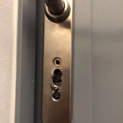 Užsitrenkusių modernių durų spyna. Bandymas išlaužti spyną